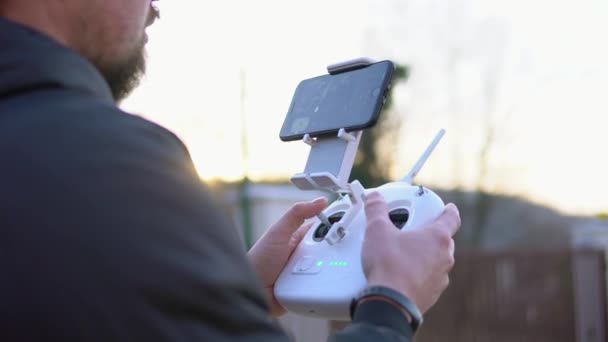 El hombre está manejando el control remoto un quadcopter con una cámara, primer plano — Vídeo de stock