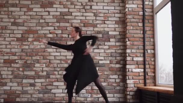 Une jeune femme fait des pas de danse, bouge les mains dans une salle de répétition — Video