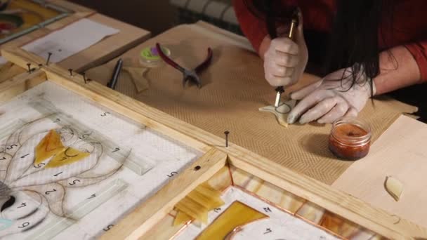 Мастер режет небольшой кусок стекла для изготовления рисунка декоративной панели — стоковое видео