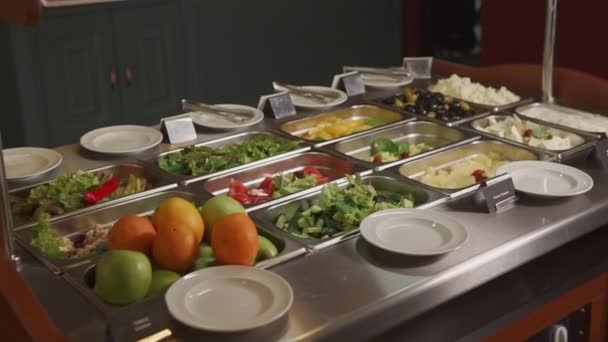 Grandes assiettes avec salades et hors-d'œuvre sur un buffet — Video