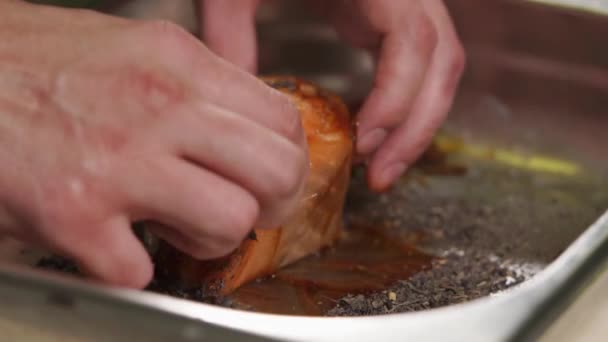 Шеф-кухар котиться рибою в траві в металевій мисці, крупним планом руками — стокове відео