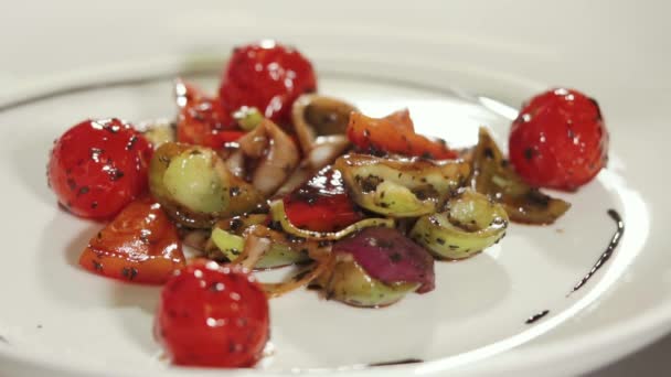 Gros plan de légumes frits sous une sauce tombante sur une assiette blanche — Video