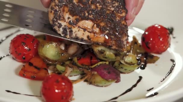 Koch legt ein saftig-leckeres Stück Fisch auf ein Gemüsekissen — Stockvideo