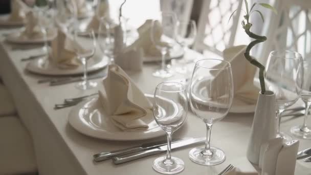 White porcelain tableware is placed on a white linen tablecloth in cafe — Stock Video