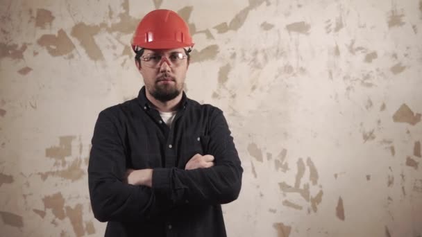 Foreman com chapéu protetor vermelho em uma cabeça está em pé dentro de casa e polegar para cima — Vídeo de Stock
