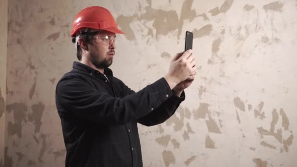 Návrhář je pořízení fotografie z bytu ve výstavbě o smartphone — Stock video