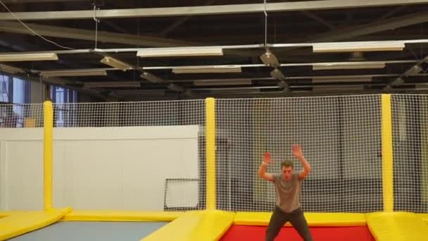 大人のスポーツマン、体育館のトランポリンでジャンプします。 — ストック動画