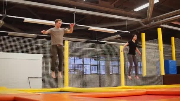 Man and woman training on a trampolines — Stock Video