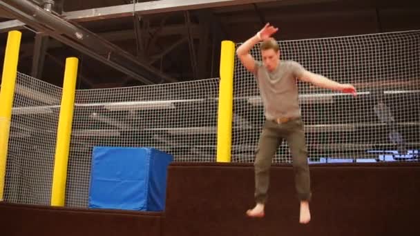 Junger Mann springt vom Sprungbrett auf dem Trampolin und schafft einen Coup — Stockvideo