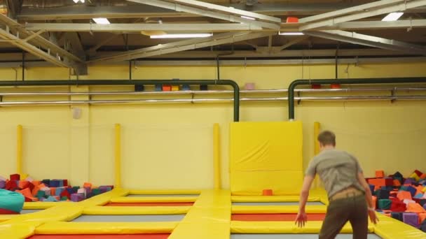 Knappe man genieten van springen op de trampoline — Stockvideo