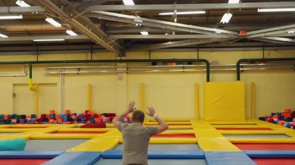 Hombre deportista divertirse en trampolines — Vídeo de stock