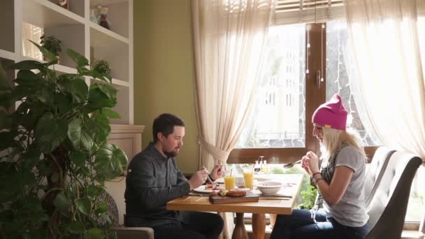 Bărbat tânăr și femeie care mănâncă într-un restaurant, un cuplu vorbind și luând cina — Videoclip de stoc