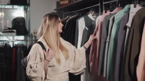 Позитивная женщина выбирает одежду — стоковое видео