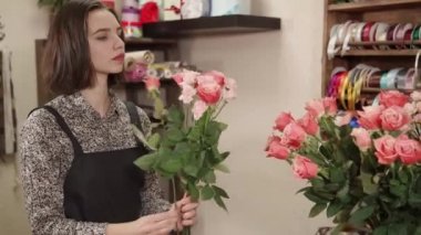 bir çiçekçi bir çiçekçi dükkanı olarak bir genç kadın çalışıyor, o bir buket oluşturur