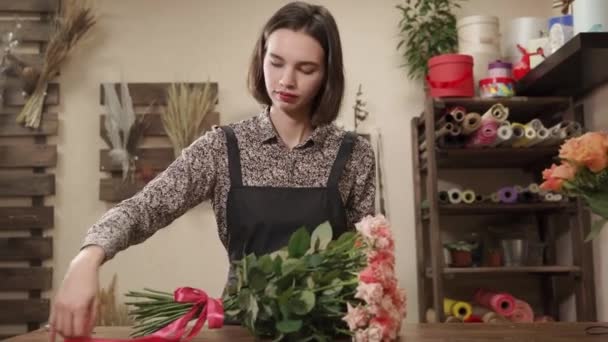 Female florist decorating a bouquet — Stock Video