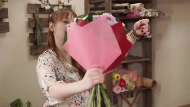 Jovem mulher coletou um buquê de flores em uma loja de flores — Vídeo de Stock