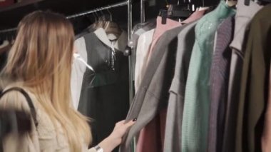 Müşteri kadın bir dükkanda alışveriş merkezi bir giysi seçimi