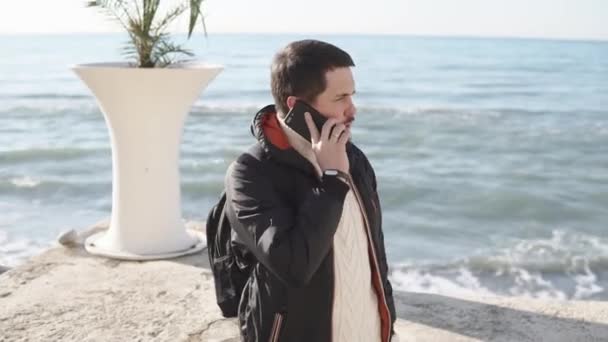 Man is talking on a smartphone on beach — Stock Video