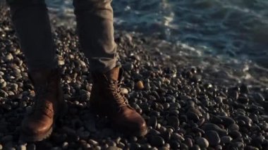 Taşlı kıyısında deniz kenarında botlar mens ayaklarda görüntüsünü kapatmak