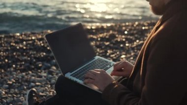 Modern yazar deniz dalganın arka planda Notebook klavye yazarak