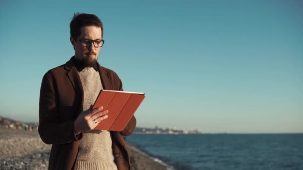 Fiatal művész a digitális kép támaszkodik a hordozható tabletta, a tenger közelében — Stock videók
