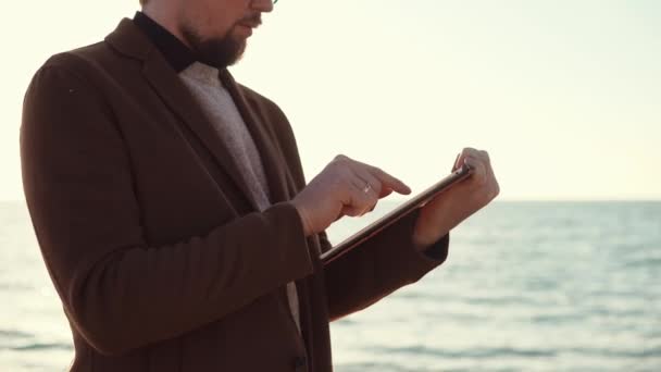 Ο άνθρωπος με το tablet σε μια παραλία — Αρχείο Βίντεο