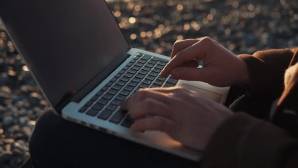 Человек, работающий на открытом ноутбуке — стоковое видео