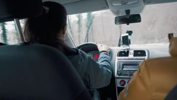 Mujer está conduciendo un coche mientras está lloviendo, ella está girando el timón a los lados — Vídeo de stock