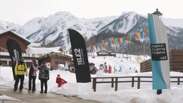 Rusland Rosa Khutor - februari, 2018: een groep toeristen lopen langs de straat — Stockvideo