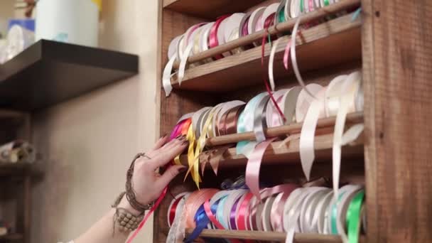 Estante con cintas de embalaje multicolores en una tienda, la mano está tirando y cortando — Vídeos de Stock