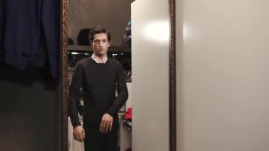 Yakışıklı adam siyah yumuşak kazak bir showroom tasarımcı Shop üzerinde çalışıyor