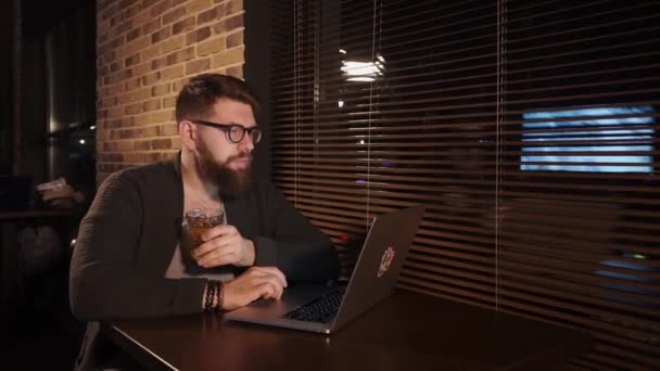 Sozinho jovem na moda está sentado no café com caderno e bebendo uísque — Vídeo de Stock