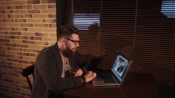 Felnőtt ember szemöldök fénykép laptop-val egy pohár szeszes ital — Stock videók