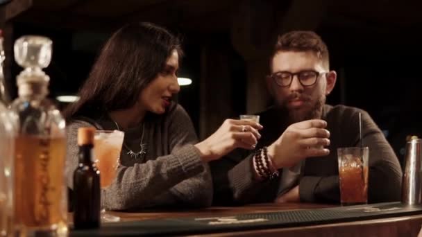 Man en vrouw is te klikken op schoten glas in een bar en drinken in de avond van de tijd — Stockvideo