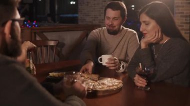 İki aile çift birlikte akşam zamanında pizzacıda yemek