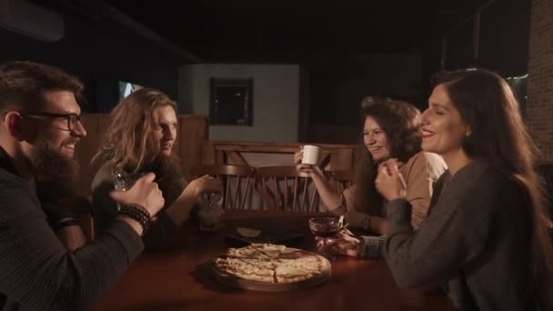 Pessoas alegres estão rindo no café, segurando óculos com bebidas alcoólicas — Vídeo de Stock