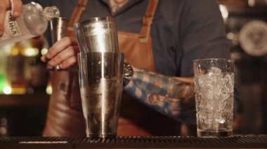 eller barmenler atış kadar yakın, bir adam votka bir ölçüm cam içine dökülen.