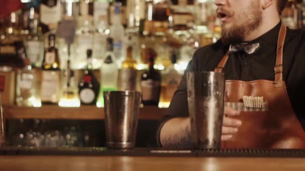 Comptoir de bar fermé où le barman est engagé dans la préparation des boissons pour les visiteurs — Video