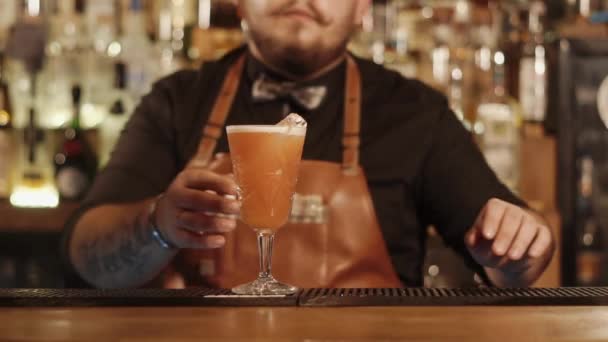 Sakallı barmen cam karışık içki ile kameraya el ile hareket ediyor — Stok video