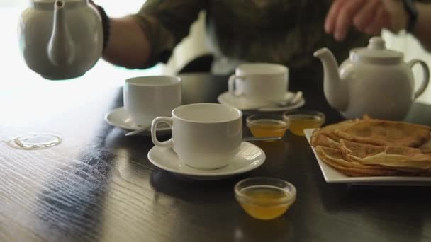 Close up tiro de um homem mãos, ele está tomando café da manhã na mesa, derramando chá — Vídeo de Stock