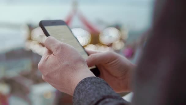 Mans van de handen met een mobiele telefoon buiten — Stockvideo