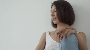 Yalnız mutlu kadın beyaz odada bir katta oturan ve özgürce nefes