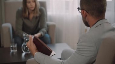 Psikanalist adam odada kadın müşteriyle görüşüyor.