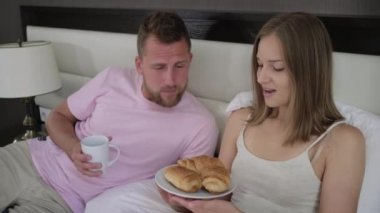 Adam karısına kahvaltı ve kahve ikram ediyor.