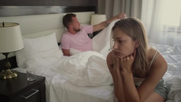 Przysięgli małżonkowie w sypialni w ciągu dnia, żona siedzi, mąż kłamie — Wideo stockowe