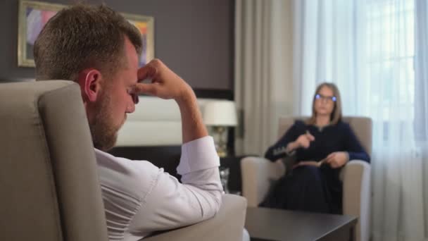 Чоловік слухає голос жінки-психоаналітика в офісі — стокове відео