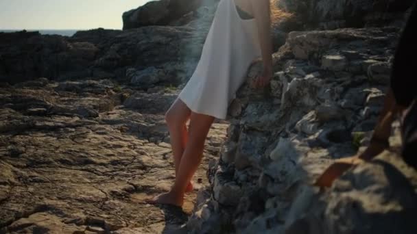 Женщина опирается на базальтовые породы у моря летом — стоковое видео