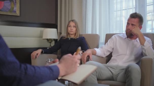 Muž a žena jsou nadávají na schůzku s manželským poradcem — Stock video