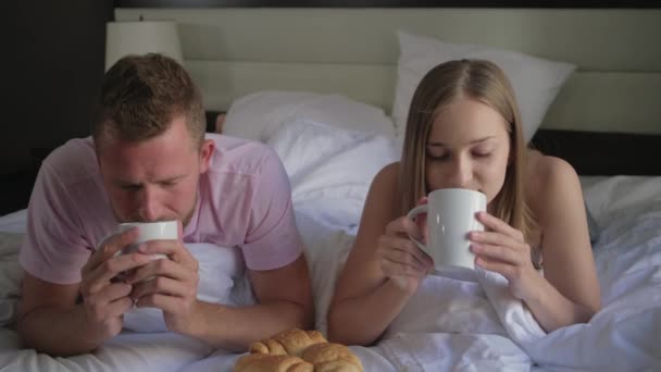 Family couple enjoying morning coffee in bed — Stockvideo