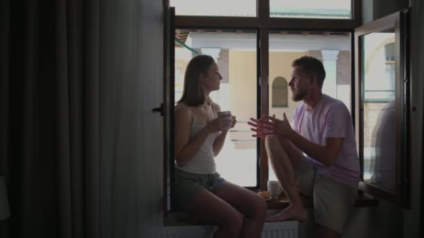 Ζευγάρι τρώει πρωινό και μιλάει στο παράθυρο — Αρχείο Βίντεο